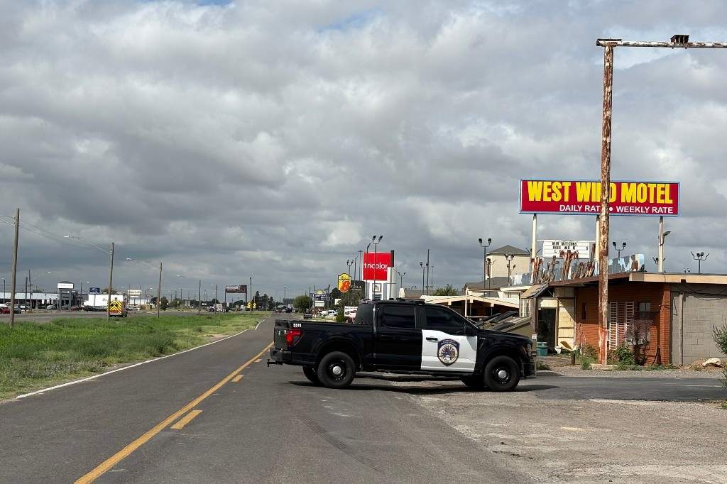 Camión de policía bloqueando la carretera cerca del West Wind Motel en Midland, Texas, tras el tiroteo que dejó un muerto y varios heridos.