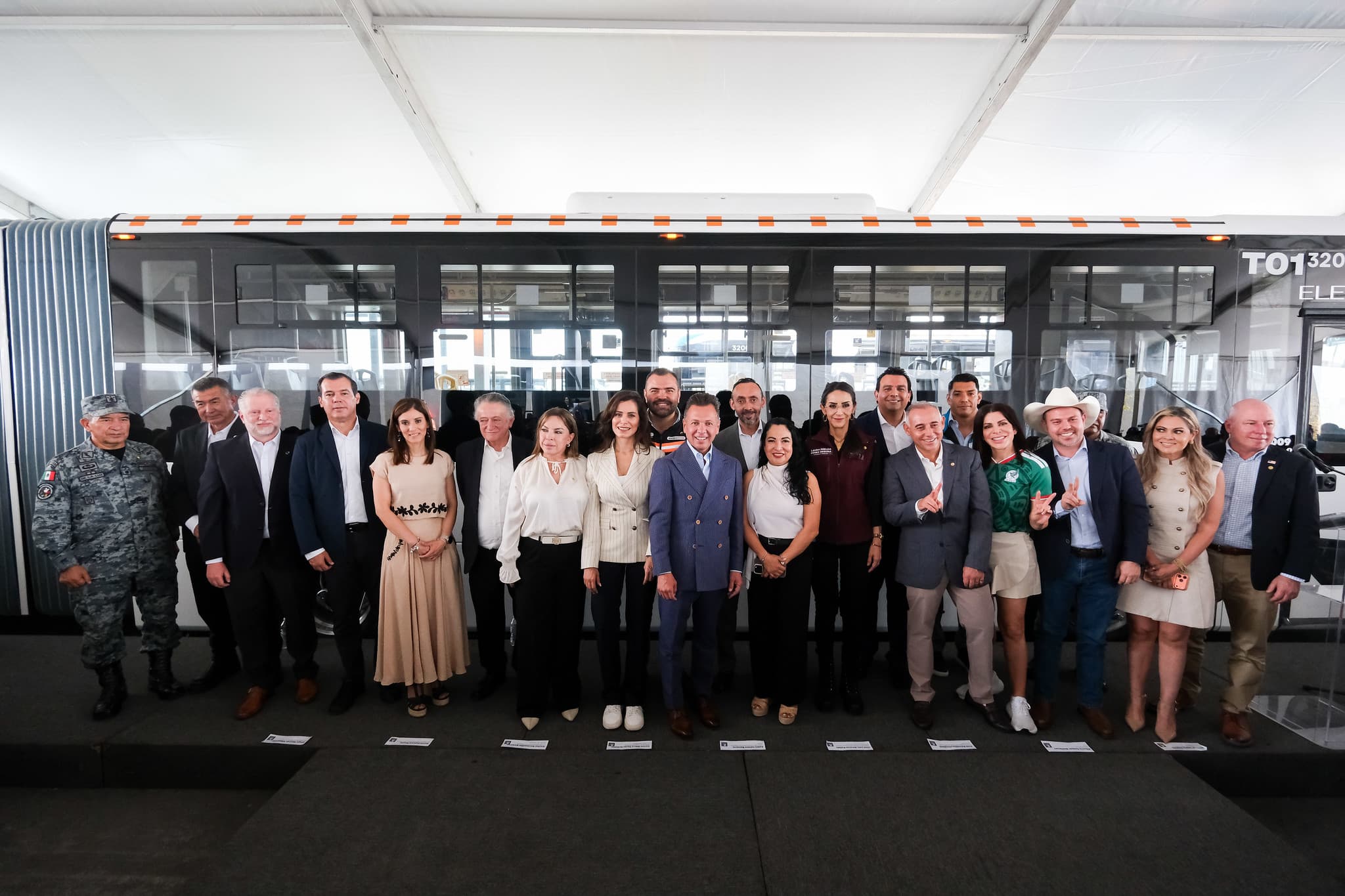 Inauguración de la Línea 5 Macro Aeropuerto en Jalisco, con autoridades y representantes de la comunidad posando frente a un autobús eléctrico.