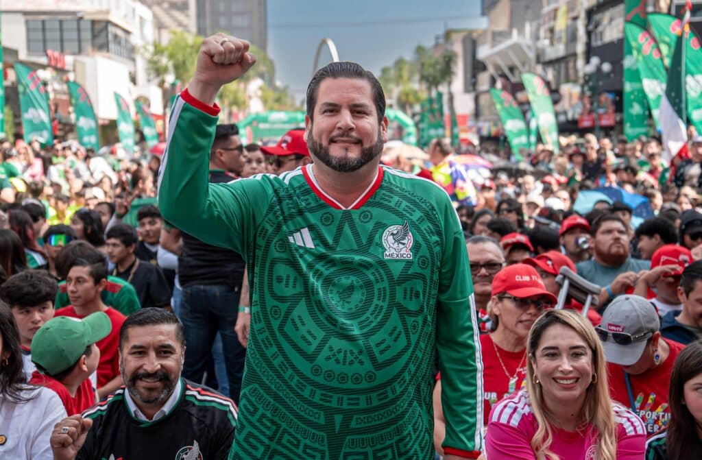 Ismael Burgueño Ruiz, con camiseta de la selección mexicana, levanta el puño en medio de una multitud durante la