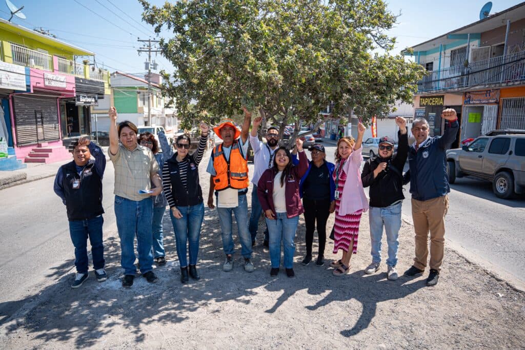 Vecinos y trabajadores del programa Tijuana Ciudad Limpia levantan la mano en señal de apoyo, en la colonia Rincón del Mediterráneo.