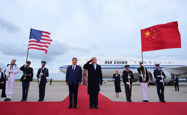 Trump saluda a Xi Jinping en la base aérea Andrews, rodeados de banderas de Estados Unidos y China durante su visita de Estado.