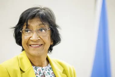 Navanethem Pillay sonríe durante una conferencia, destacando su compromiso con los derechos humanos y la justicia internacional.