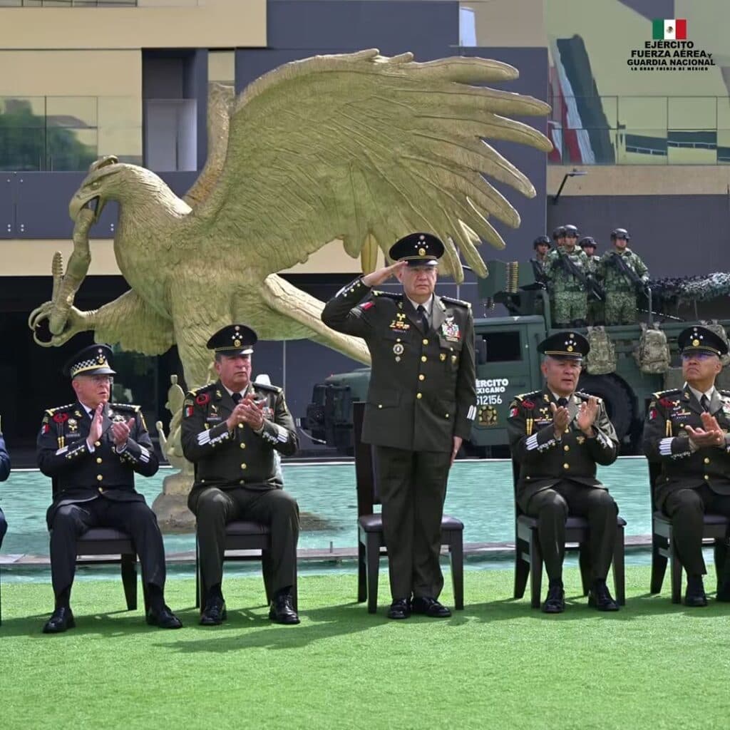 Ceremonia del 205 aniversario de la Sedena, con el general Trevilla en el centro, saludando mientras otros oficiales aplauden.